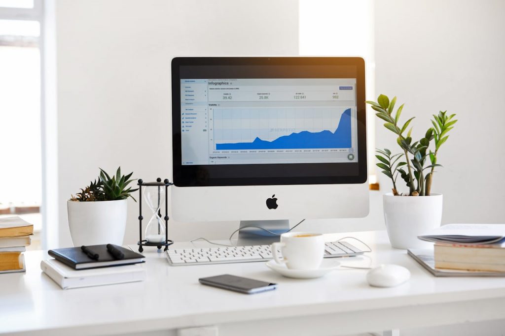 pexels-photo-572056 A clean, contemporary workspace featuring a desktop with analytics on the screen and plants for a fresh look.